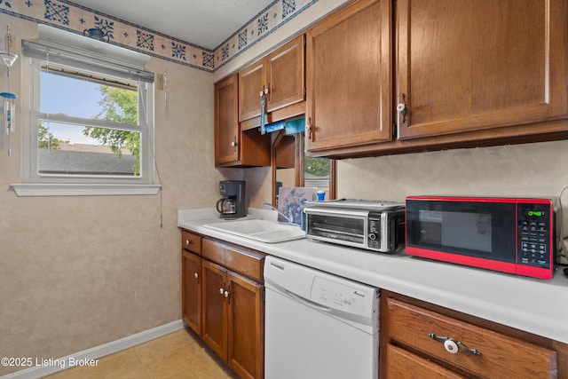 710 Victoria Ct, New Albany, IN 47150 - kitchen with dishwasher, brown cabinets, and light countertops