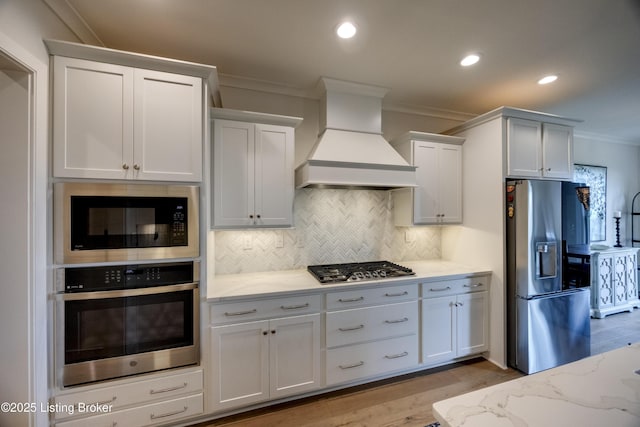 1605 Meremont Ridge Rd, Louisville, KY 40245 - kitchen with stainless steel appliances, custom range hood, crown molding, light wood-style flooring, and light stone counters