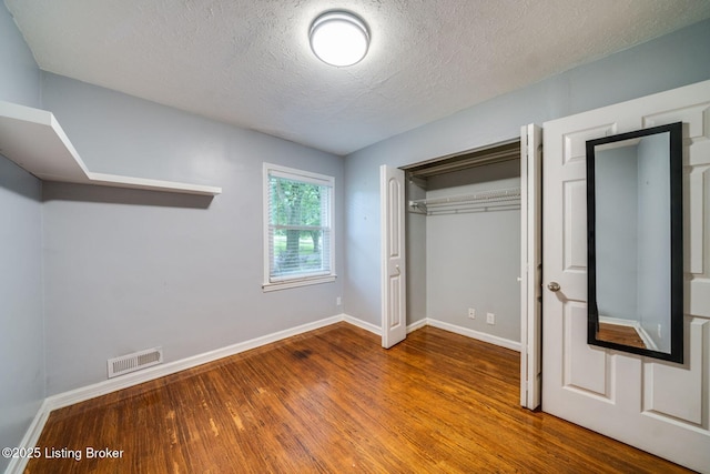 4229 Hillbrook Dr, Louisville, KY 40220 - unfurnished bedroom with wood finished floors, a closet, and a textured ceiling
