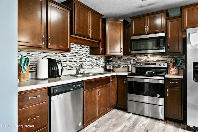 120 Spring Leaf Ct, Shelbyville, KY 40065 - kitchen featuring stainless steel appliances, light countertops, decorative backsplash, light wood-type flooring, and a textured ceiling