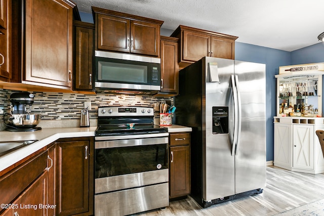 120 Spring Leaf Ct, Shelbyville, KY 40065 - kitchen with appliances with stainless steel finishes, light wood-type flooring, light countertops, and tasteful backsplash
