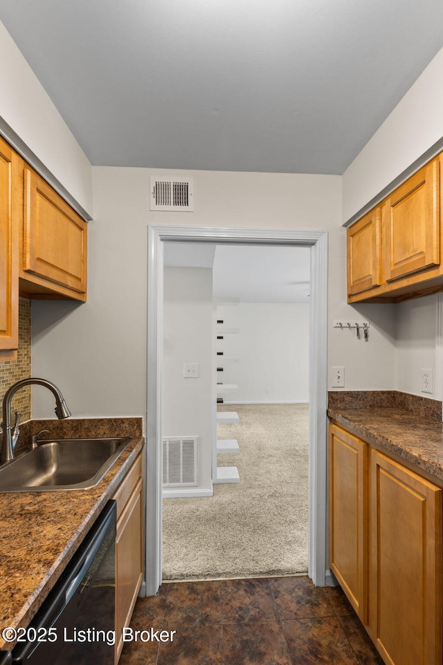 521 Zorn Ave Unit E15, Louisville, KY 40206 - kitchen with black dishwasher, dark countertops, dark colored carpet, brown cabinetry, and dark stone finish flooring