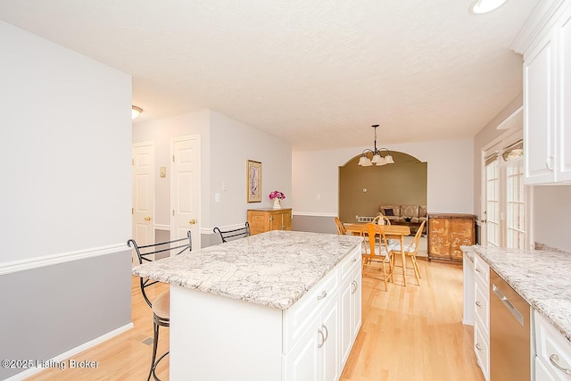 13811 Forest Bend Cir, Louisville, KY 40245 - kitchen featuring light wood-style floors, white cabinetry, a breakfast bar, a chandelier, and dishwasher
