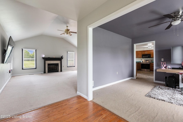 9071 Charleston Way, Shelbyville, KY 40065 - living room featuring a ceiling fan, light colored carpet, a glass covered fireplace, lofted ceiling, and light wood finished floors
