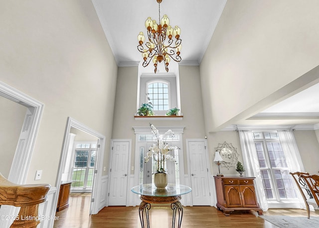 3221 Overlook Ridge Rd, Prospect, KY 40059 - foyer featuring wood finished floors, a chandelier, crown molding, a towering ceiling, and a wainscoted wall