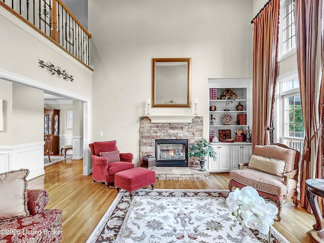 3221 Overlook Ridge Rd, Prospect, KY 40059 - living area with a towering ceiling, light wood-type flooring, a stone fireplace, and wainscoting