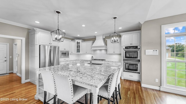 3221 Overlook Ridge Rd, Prospect, KY 40059 - kitchen featuring appliances with stainless steel finishes, custom exhaust hood, a chandelier, ornamental molding, and white cabinets