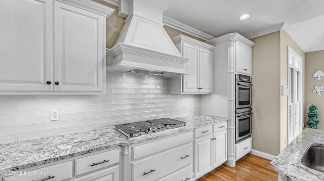 3221 Overlook Ridge Rd, Prospect, KY 40059 - kitchen with stainless steel appliances, premium range hood, white cabinets, light wood-style flooring, and tasteful backsplash