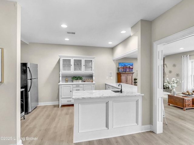 3221 Overlook Ridge Rd, Prospect, KY 40059 - kitchen with freestanding refrigerator, light wood-style floors, white cabinetry, and recessed lighting