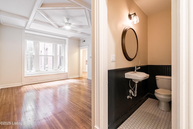 1629 S 3rd St Apt 102, Louisville, KY 40208 - half bathroom featuring coffered ceiling, wood finished floors, a ceiling fan, and wainscoting
