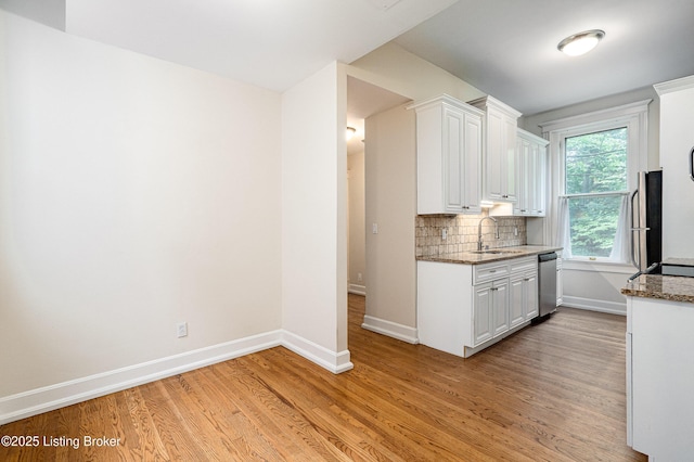 1629 S 3rd St Apt 102, Louisville, KY 40208 - kitchen featuring light wood finished floors, white cabinetry, dishwasher, backsplash, and dark stone counters