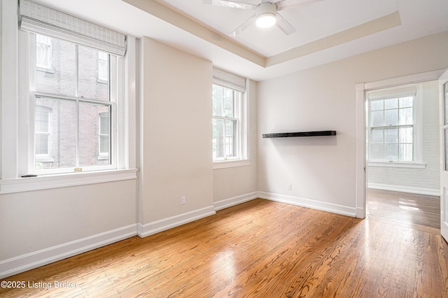 1629 S 3rd St Apt 102, Louisville, KY 40208 - spare room featuring wood finished floors, ceiling fan, and a tray ceiling