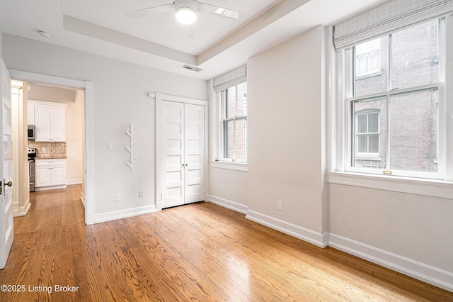 1629 S 3rd St Apt 102, Louisville, KY 40208 - unfurnished bedroom featuring light wood-type flooring, a closet, and a raised ceiling