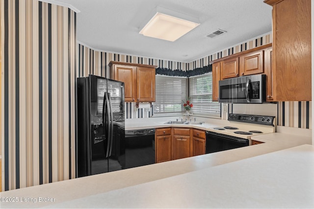 8001 Port Royal Ct, Louisville, KY 40291 - kitchen with black appliances, wallpapered walls, light countertops, brown cabinetry, and a textured ceiling