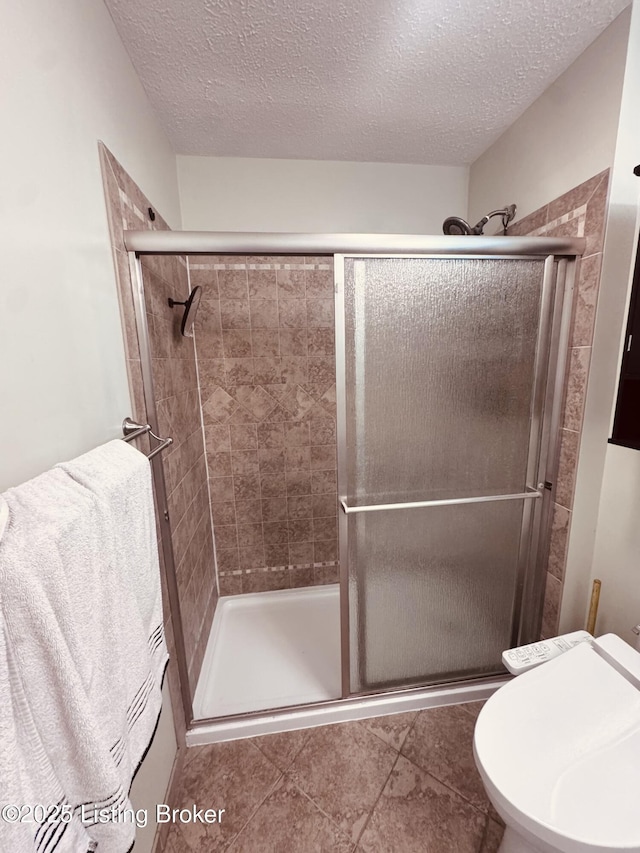 5019 S Wilson Rd, Elizabethtown, KY 42701 - bathroom featuring a stall shower, a textured ceiling, and tile patterned floors