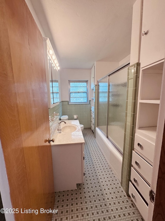 5019 S Wilson Rd, Elizabethtown, KY 42701 - bathroom featuring vanity, tile patterned floors, combined bath / shower with glass door, and a wainscoted wall