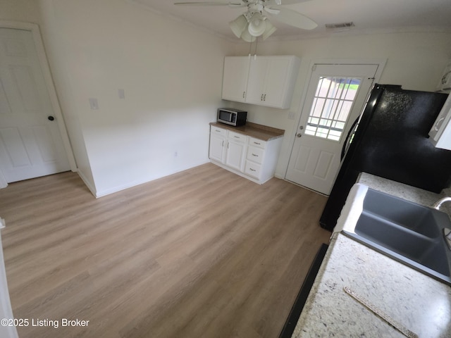 8308 Lake Superior Dr, Louisville, KY 40291 - kitchen with stainless steel microwave, ceiling fan, ornamental molding, light wood-style floors, and white cabinetry