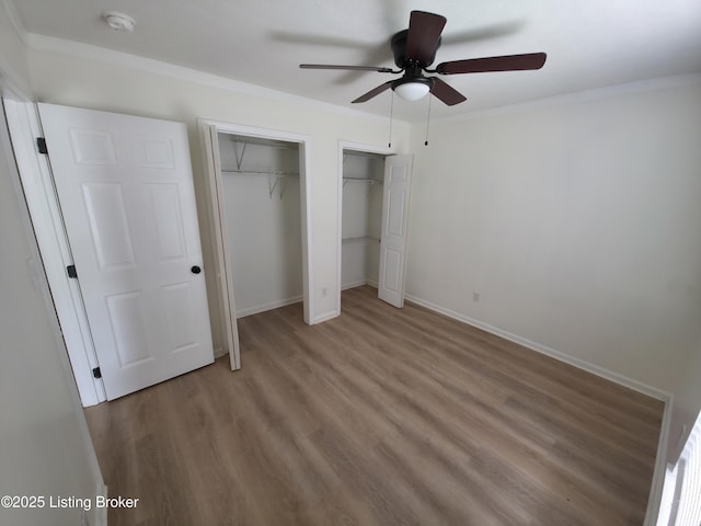 8308 Lake Superior Dr, Louisville, KY 40291 - unfurnished bedroom featuring multiple closets, wood finished floors, and ceiling fan