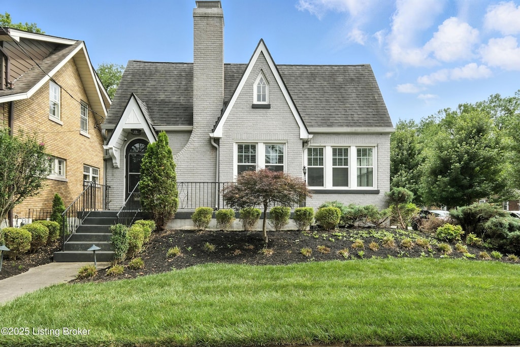 3500 Lexington Rd, Louisville, KY 40207 - view of front of property with brick siding, a chimney, a front yard, and roof with shingles