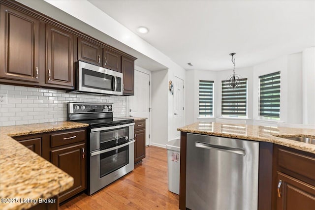 9311 Artis Way, Louisville, KY 40291 - kitchen featuring stainless steel appliances, light wood-type flooring, dark brown cabinetry, backsplash, and light stone counters
