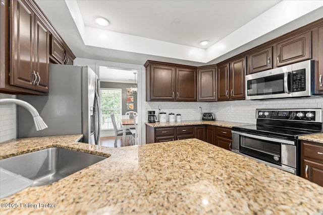9311 Artis Way, Louisville, KY 40291 - kitchen featuring stainless steel appliances, dark brown cabinetry, decorative backsplash, light stone counters, and a raised ceiling