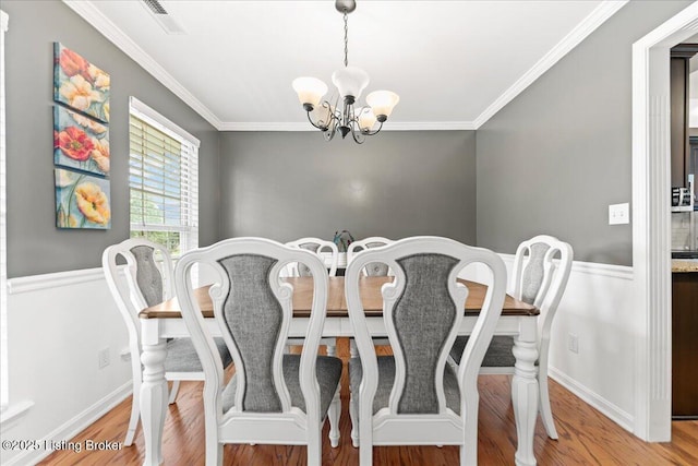 9311 Artis Way, Louisville, KY 40291 - dining area featuring a chandelier, ornamental molding, wood finished floors, and wainscoting
