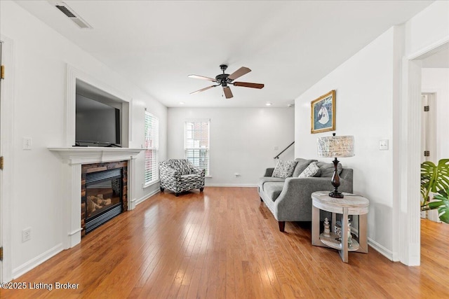 9311 Artis Way, Louisville, KY 40291 - living area with wood-type flooring, a ceiling fan, and a glass covered fireplace