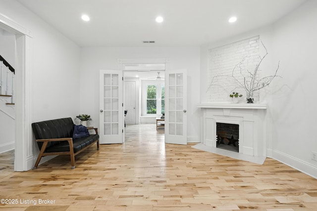 143 State St, Louisville, KY 40206 - sitting room with french doors, wood finished floors, recessed lighting, and a fireplace with flush hearth
