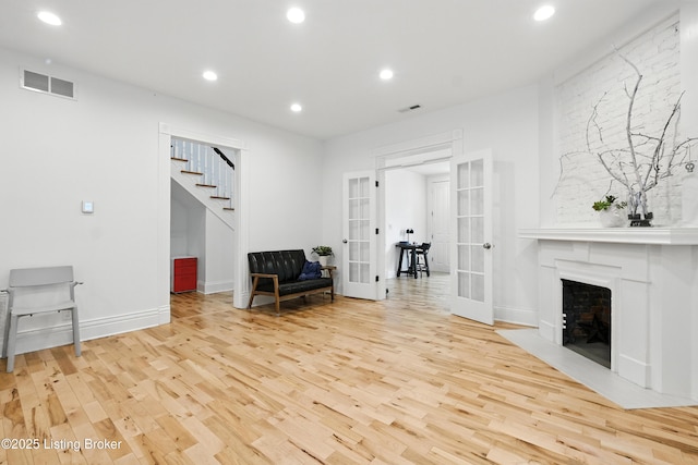 143 State St, Louisville, KY 40206 - sitting room with french doors, wood finished floors, stairs, recessed lighting, and a large fireplace