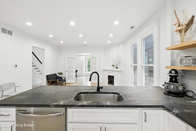 143 State St, Louisville, KY 40206 - kitchen with dishwasher, white cabinets, recessed lighting, dark stone counters, and a fireplace