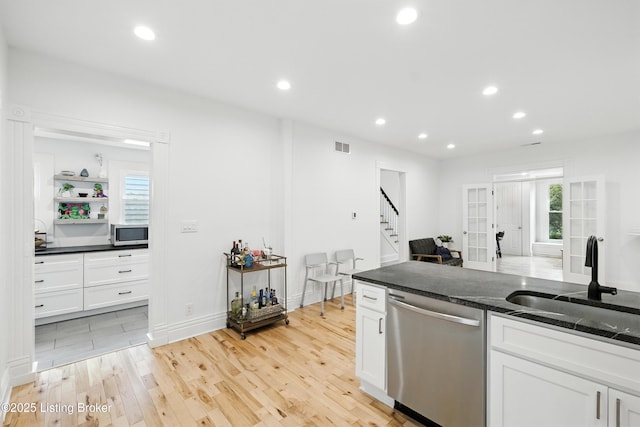 143 State St, Louisville, KY 40206 - kitchen featuring stainless steel appliances, light wood-style floors, dark stone countertops, white cabinets, and recessed lighting