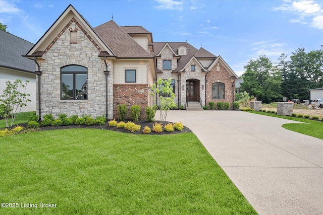 6511 Rosecliff Ct, Prospect, KY 40059 - french country home featuring a front yard, stone siding, concrete driveway, and roof with shingles