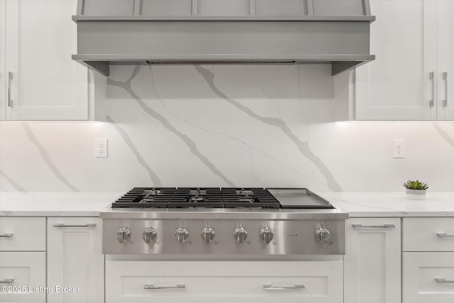 6511 Rosecliff Ct, Prospect, KY 40059 - kitchen view of stainless steel gas stovetop, extractor fan, white cabinetry, and light stone counters