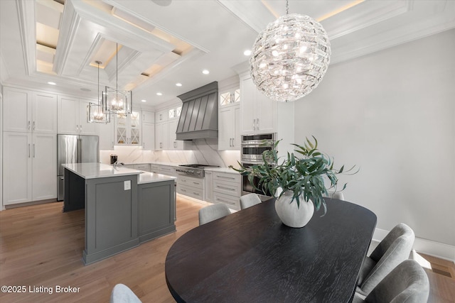 6511 Rosecliff Ct, Prospect, KY 40059 - kitchen featuring a chandelier, custom exhaust hood, appliances with stainless steel finishes, crown molding, and light countertops
