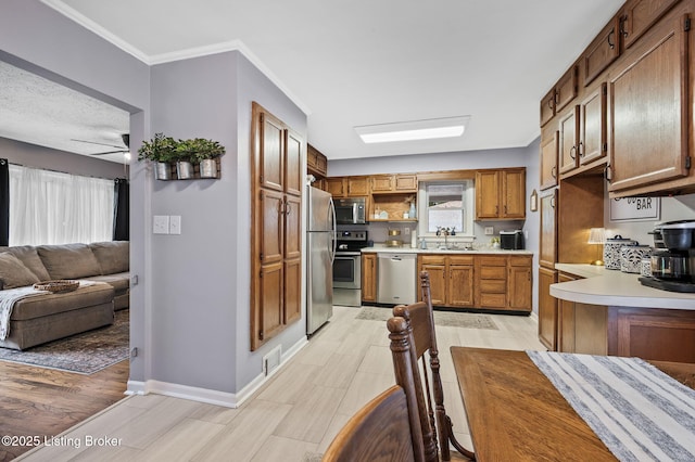 8433 Chase Rd, Louisville, KY 40258 - kitchen with appliances with stainless steel finishes, light countertops, open floor plan, wood tiled floors, and brown cabinets