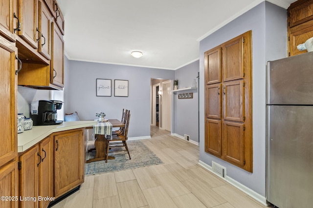 8433 Chase Rd, Louisville, KY 40258 - kitchen featuring freestanding refrigerator, light countertops, crown molding, brown cabinetry, and an office area
