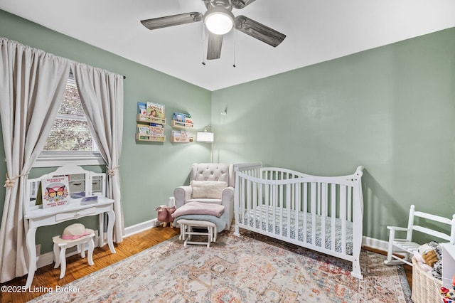 8433 Chase Rd, Louisville, KY 40258 - bedroom with a crib, wood finished floors, and a ceiling fan
