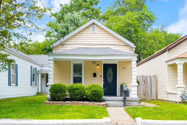 631 Lynn St, Louisville, KY 40217 - shotgun-style home featuring a shingled roof and a porch