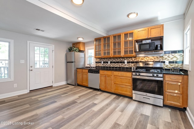 631 Lynn St, Louisville, KY 40217 - kitchen with appliances with stainless steel finishes, dark countertops, decorative backsplash, and light wood finished floors