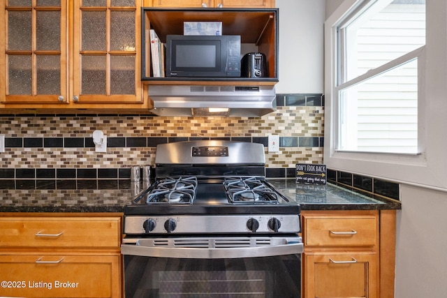 631 Lynn St, Louisville, KY 40217 - kitchen with stainless steel gas range oven, under cabinet range hood, black microwave, glass insert cabinets, and backsplash