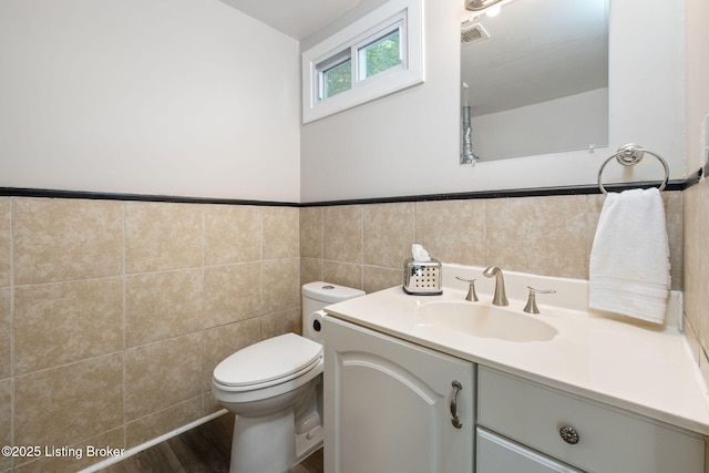 631 Lynn St, Louisville, KY 40217 - bathroom featuring tile walls, vanity, a wainscoted wall, and wood finished floors