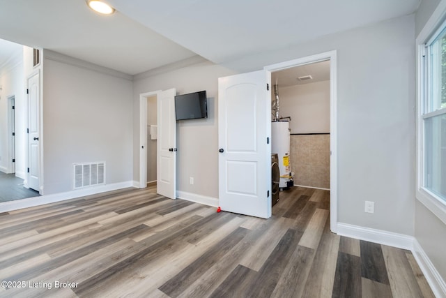 631 Lynn St, Louisville, KY 40217 - unfurnished bedroom featuring gas water heater and wood finished floors