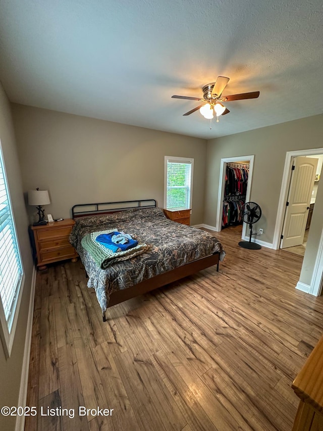 68 Lonnie Lawson Ct, Brandenburg, KY 40108 - bedroom with wood finished floors, a walk in closet, a closet, and a ceiling fan