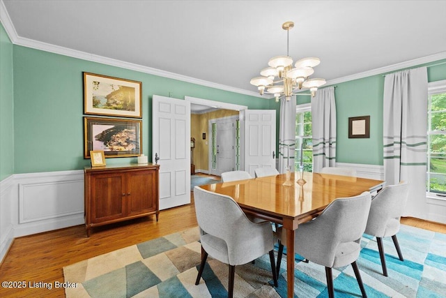 5612 Apache Rd, Louisville, KY 40207 - dining space featuring a chandelier, healthy amount of natural light, light wood finished floors, crown molding, and a wainscoted wall