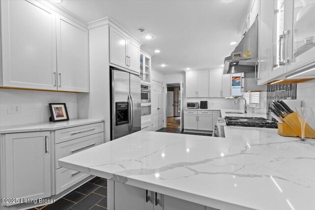 5612 Apache Rd, Louisville, KY 40207 - kitchen with stainless steel appliances, under cabinet range hood, tasteful backsplash, white cabinetry, and recessed lighting