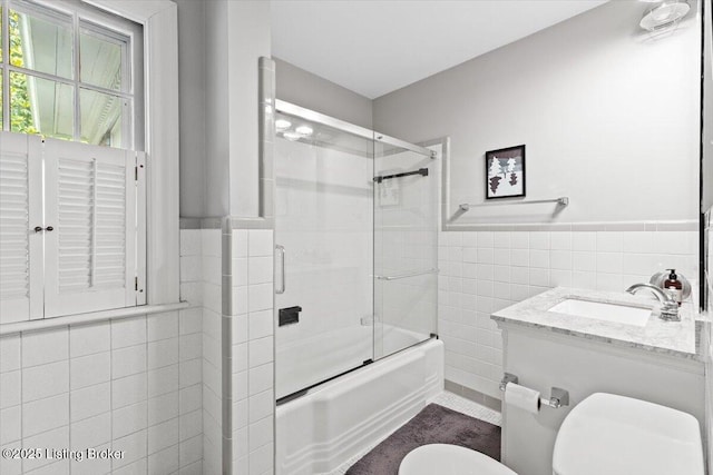 5612 Apache Rd, Louisville, KY 40207 - bathroom featuring tile walls, combined bath / shower with glass door, wainscoting, and vanity