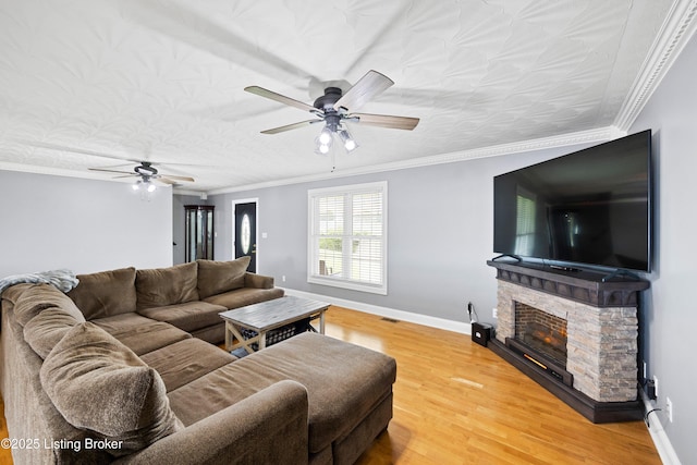 192 Loretto Rd, Springfield, KY 40069 - living area with ceiling fan, a stone fireplace, light wood finished floors, and crown molding