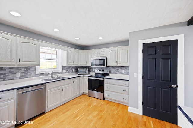 192 Loretto Rd, Springfield, KY 40069 - kitchen with stainless steel appliances, light wood-style flooring, decorative backsplash, white cabinets, and recessed lighting