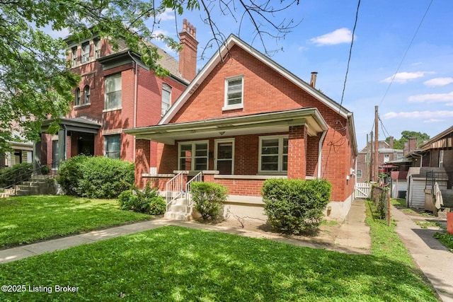 1721 S 4th St, Louisville, KY 40208 - view of front of property with brick siding, covered porch, a front yard, and a chimney