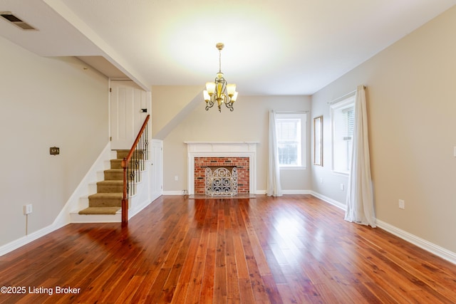 2990 Cedar Grove Rd, Shepherdsville, KY 40165 - unfurnished living room with a chandelier, hardwood / wood-style flooring, stairs, and a brick fireplace